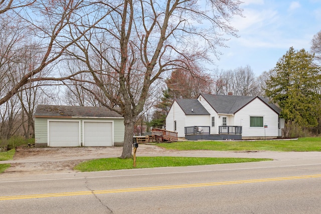 view of front of home with dirt driveway, a garage, a front lawn, an outdoor structure, and a deck