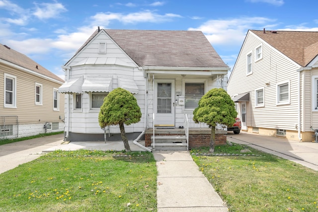 view of front of property featuring a front lawn, entry steps, and roof with shingles