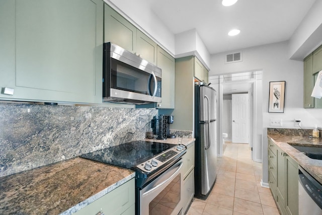 3553 Port Cove Dr Unit 37, Waterford, MI 48328 - kitchen with light tile patterned floors, green cabinetry, visible vents, stainless steel appliances, and backsplash