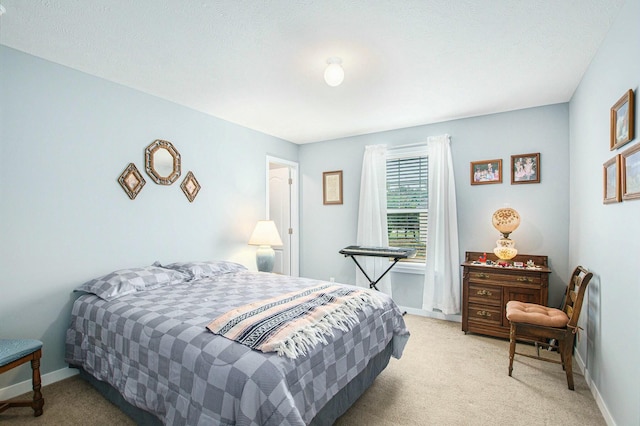 bedroom with baseboards and light colored carpet