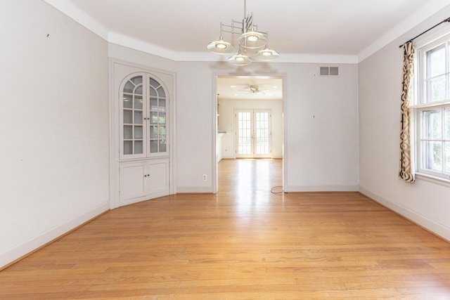 unfurnished dining area featuring light wood-style floors, plenty of natural light, and visible vents