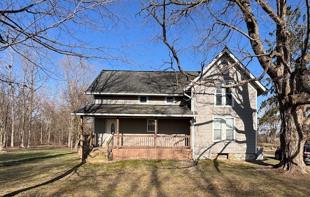 traditional-style house with a porch and a front yard