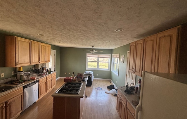 kitchen featuring stainless steel dishwasher, a kitchen island, freestanding refrigerator, baseboards, and wood finished floors