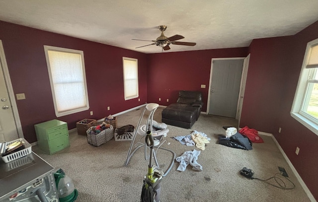 unfurnished living room featuring baseboards, a ceiling fan, and carpet