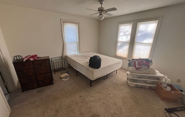 carpeted bedroom with a ceiling fan and multiple windows