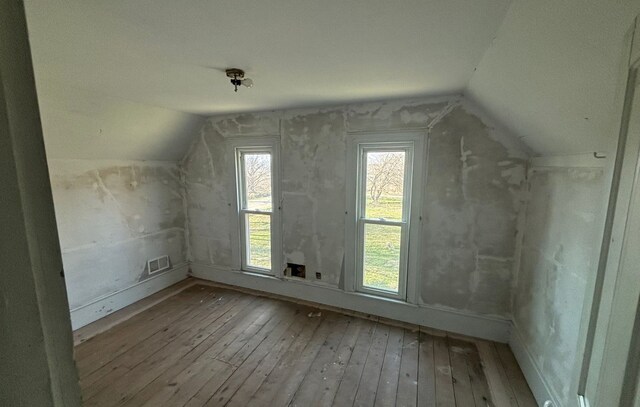 bonus room featuring wood-type flooring, lofted ceiling, visible vents, and baseboards