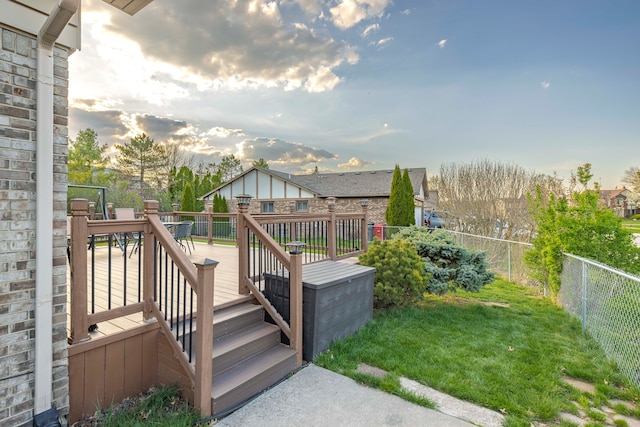 wooden terrace with a lawn and a fenced backyard