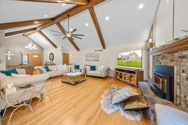 living area with a wood stove, beam ceiling, wood finished floors, ceiling fan with notable chandelier, and recessed lighting