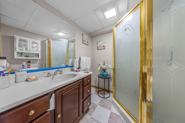 bathroom featuring vanity, a stall shower, and a drop ceiling