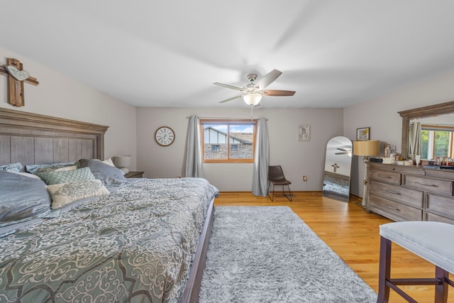 bedroom featuring baseboards, ceiling fan, and light wood finished floors