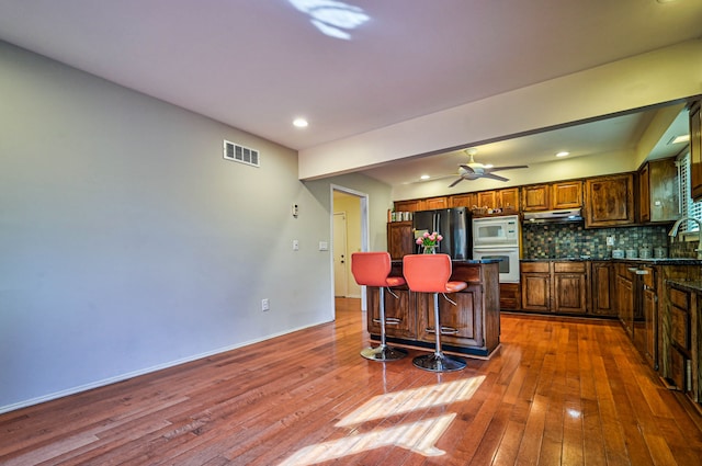 3052 Westman Ct, Bloomfield Hills, MI 48304 - kitchen with visible vents, a sink, freestanding refrigerator, white microwave, and hardwood / wood-style flooring