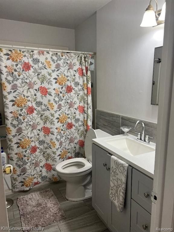 41541 Mcbride Ave, Van Buren, MI 48111 - full bathroom with curtained shower, wood finished floors, toilet, vanity, and tasteful backsplash
