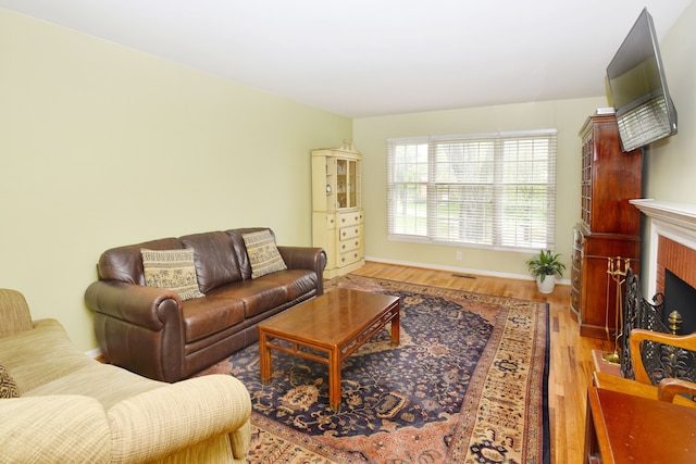 living room with wood finished floors, a fireplace, and baseboards
