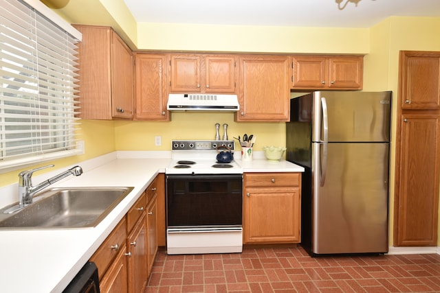kitchen with freestanding refrigerator, white electric range oven, extractor fan, a sink, and brick patterned floors