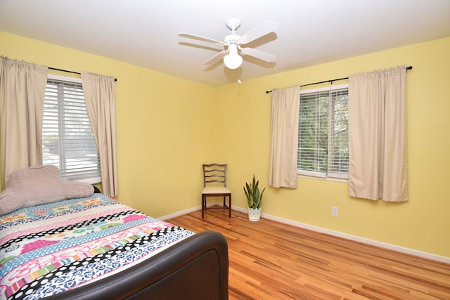 bedroom with wood finished floors, baseboards, and ceiling fan