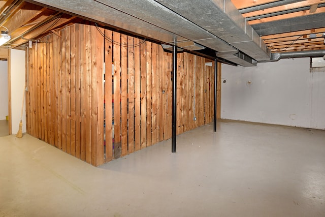 unfinished basement featuring wooden walls