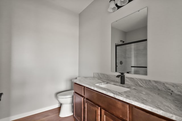 10820 Baker Rd, Jerome, MI 49249 - bathroom with toilet, vanity, a shower with door, baseboards, and wood finished floors