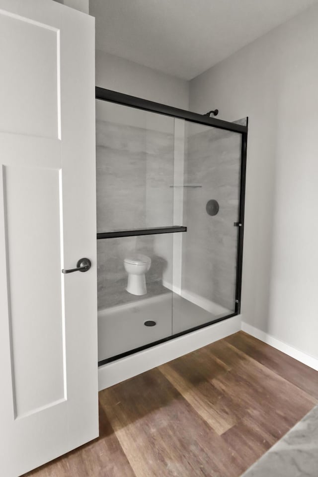 10820 Baker Rd, Jerome, MI 49249 - bathroom featuring wood finished floors, a shower stall, and toilet