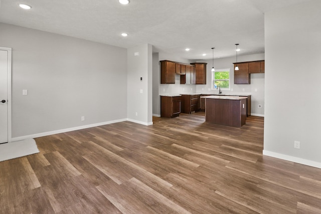 10820 Baker Rd, Jerome, MI 49249 - kitchen featuring dark wood-style floors, recessed lighting, a kitchen island, baseboards, and pendant lighting