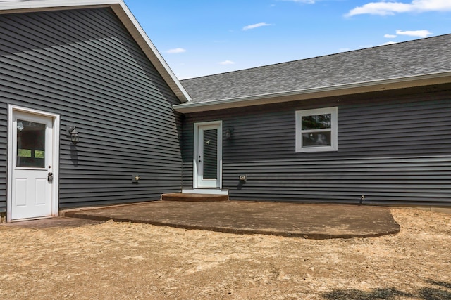 10820 Baker Rd, Jerome, MI 49249 - back of house featuring a shingled roof and a patio