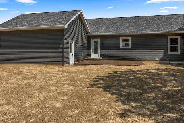 10820 Baker Rd, Jerome, MI 49249 - back of house featuring a shingled roof and a patio
