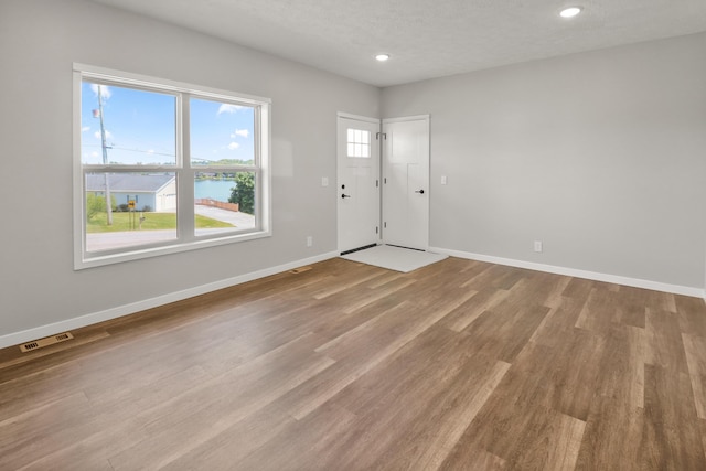 10820 Baker Rd, Jerome, MI 49249 - entrance foyer featuring a water view, baseboards, wood finished floors, recessed lighting, and a textured ceiling