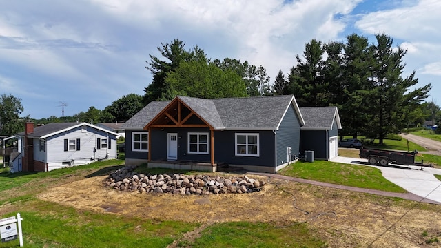10820 Baker Rd, Jerome, MI 49249 - view of front facade with covered porch, concrete driveway, a garage, a front lawn, and roof with shingles