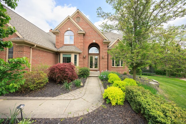 24160 Argyle St, Novi, MI 48374 - traditional home featuring french doors, brick siding, a shingled roof, a front lawn, and a trampoline