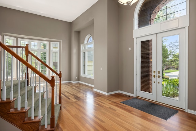 24160 Argyle St, Novi, MI 48374 - entryway featuring light wood-style floors, french doors, stairs, baseboards, and a towering ceiling