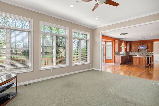24160 Argyle St, Novi, MI 48374 - unfurnished living room with healthy amount of natural light, light colored carpet, a ceiling fan, ornamental molding, and baseboards
