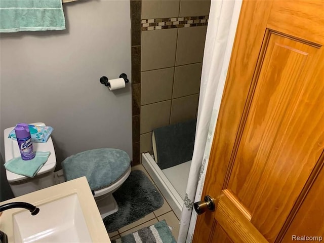full bath featuring tile patterned floors, a sink, a shower stall, and toilet