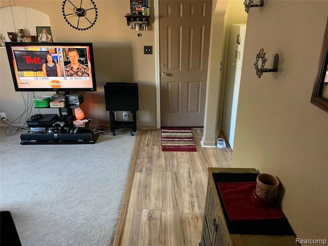 interior space with baseboards, wood finished floors, and arched walkways