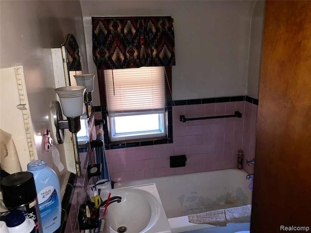 full bath featuring a tub and a sink