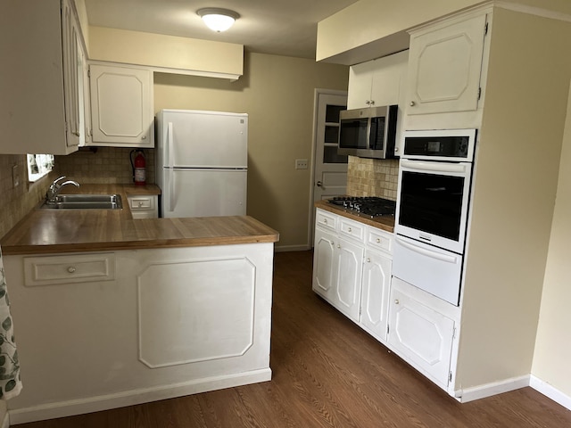 2120 Hemlock Ave, Portage, MI 49024 - kitchen with stainless steel appliances, a sink, a warming drawer, a peninsula, and decorative backsplash