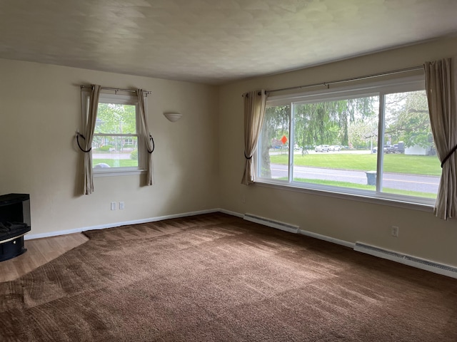 2120 Hemlock Ave, Portage, MI 49024 - unfurnished living room featuring a wood stove, a baseboard heating unit, carpet flooring, and baseboards