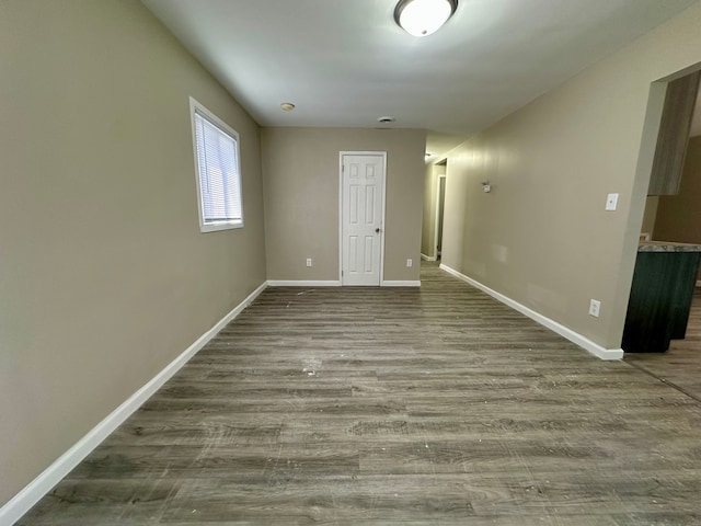 spare room featuring wood finished floors and baseboards