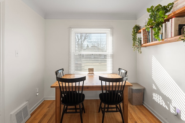 dining area featuring baseboards, wood finished floors, and visible vents