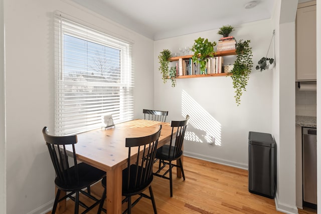 dining area with light wood-style floors and baseboards