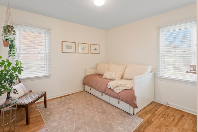 interior space featuring baseboards, multiple windows, and light wood-style floors