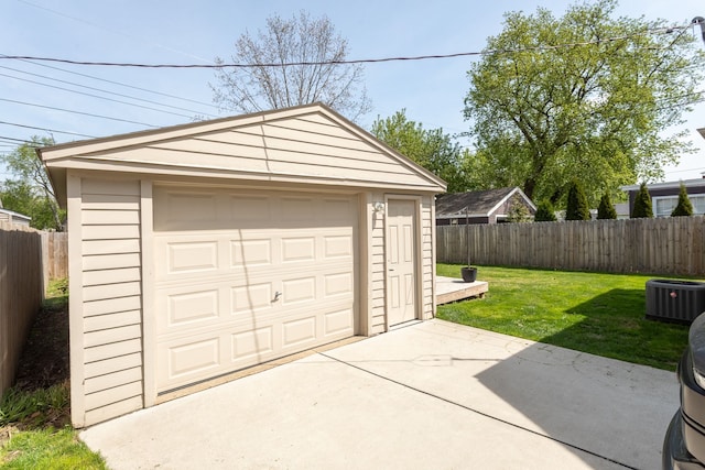 detached garage featuring fence, concrete driveway, and central AC
