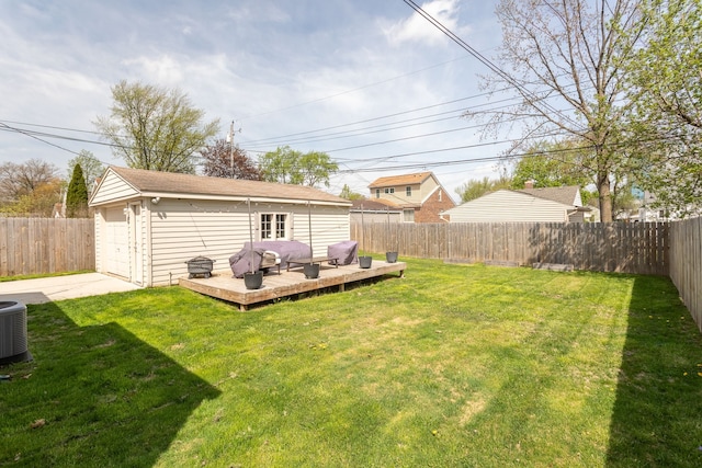 view of yard with a wooden deck, central AC unit, a detached garage, a fenced backyard, and concrete driveway