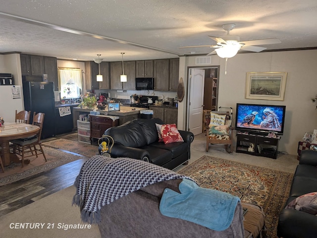 living area with ceiling fan, a textured ceiling, visible vents, and carpet