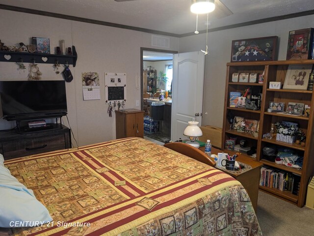 bedroom with crown molding, visible vents, and carpet