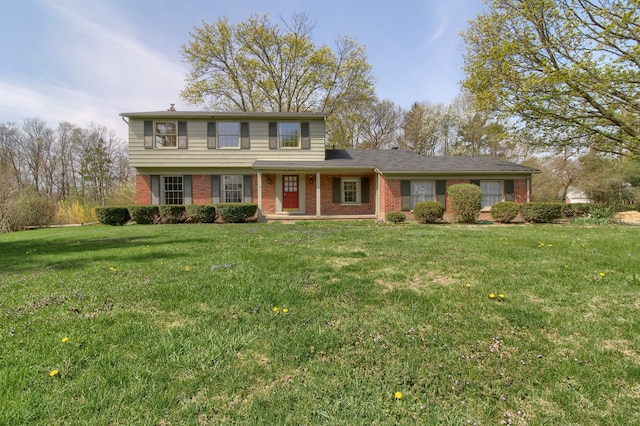 traditional home featuring a front yard and brick siding
