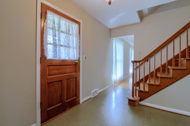 foyer with stairway, visible vents, and baseboards
