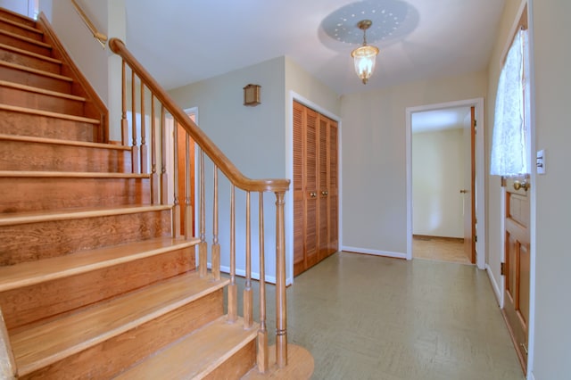 foyer entrance with tile patterned floors, baseboards, and stairs