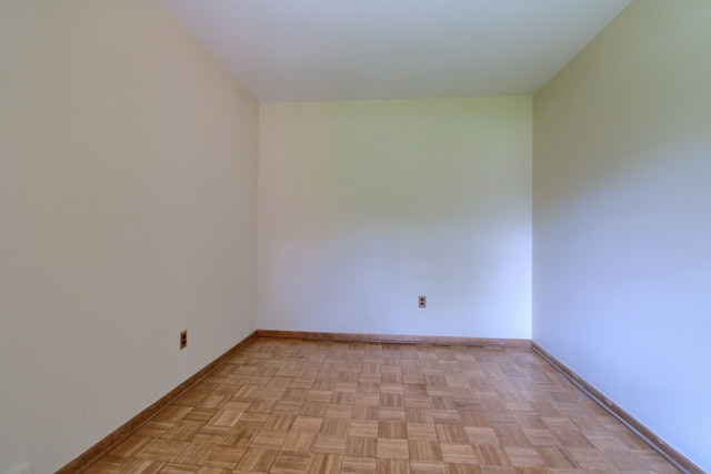 unfurnished room with baseboards