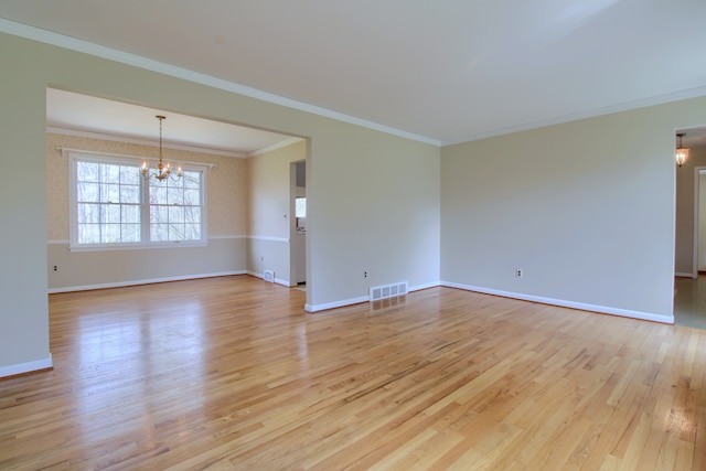 unfurnished room with light wood-style flooring, visible vents, baseboards, ornamental molding, and a notable chandelier