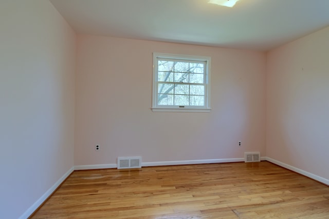 empty room with visible vents, baseboards, and light wood-type flooring