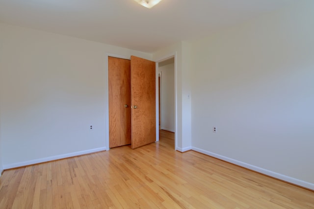 empty room featuring light wood-style flooring and baseboards